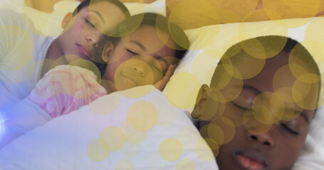 Image of dots moving over sleeping african american mother and kids