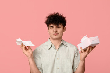 Young man with tissues on pink background. Allergy concept