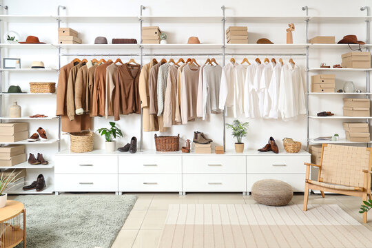Interior of modern dressing room with wardrobe boxes, stylish clothes and accessories - Powered by Adobe