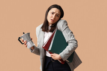 Stressed businesswoman with phone and documents drinking coffee on beige background. Deadline...