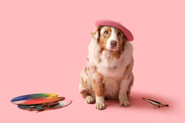 Cute dog with artist's tools on pink background