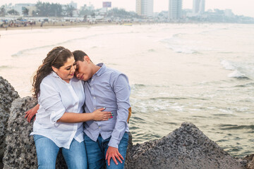 Fototapeta premium Latin mother and son enjoying the sunset hugging each other looking at camera