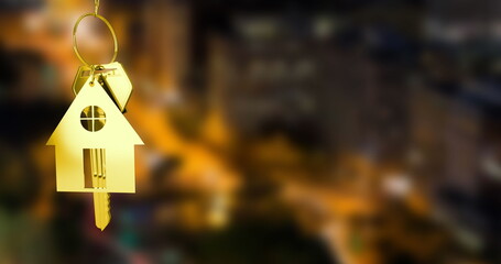 Image of gold house key and fob over out of focus cityscape