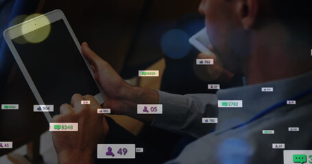 Image of social media icons floating over mid section of a man using digital tablet