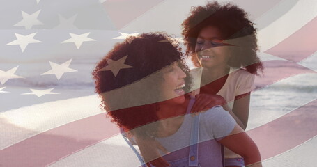 Image of flag of usa over happy african american mother with daughter on beach