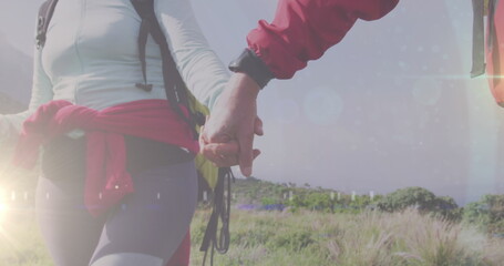 Caucasian couple, both fitness instructors, holding hands while hiking