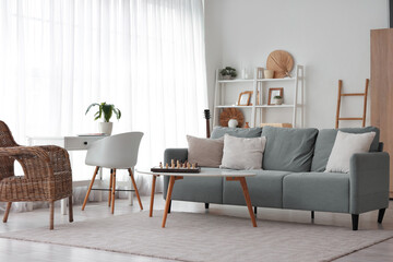 Interior of cozy living room with sofa and chess board on coffee table