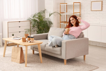 Young woman eating Asian food on sofa at home