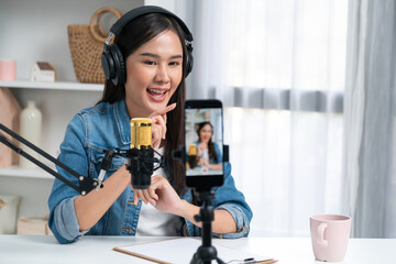 Host channel Asian influencer talking in broadcast wearing headsets on social media live on...
