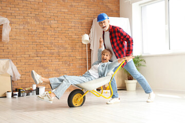 Mature couple with trolley having fun during repair in room