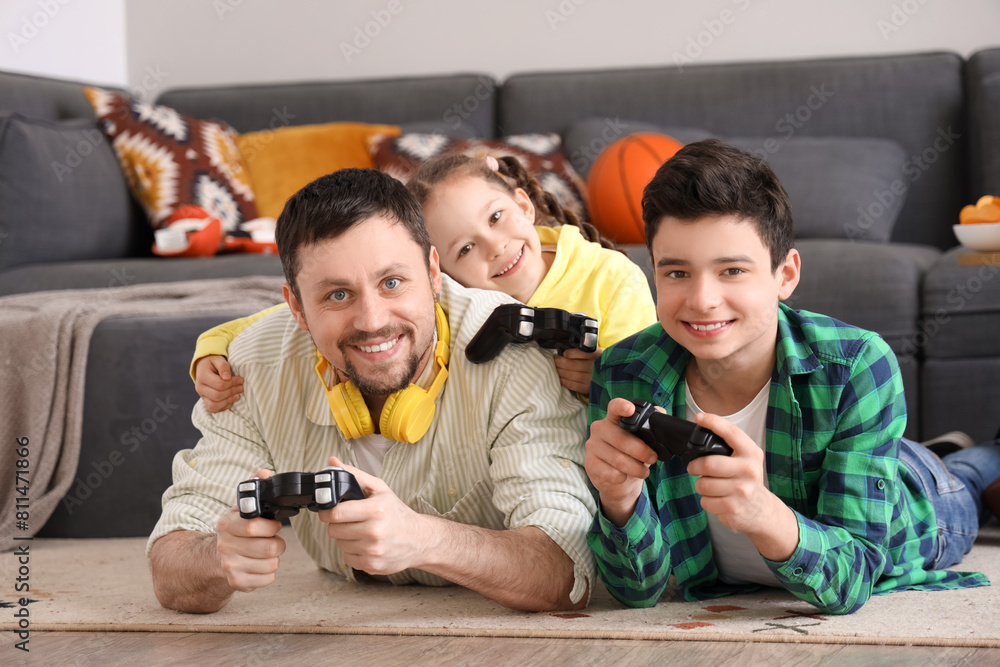 Wall mural happy father with his little children playing video game on floor at home - Wall murals