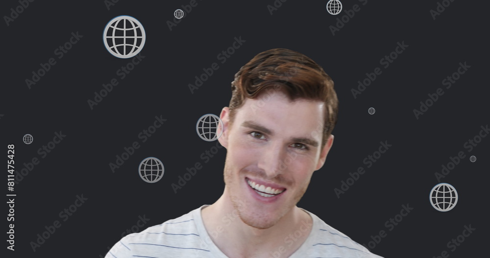 Poster image of multiple web globe icons floating over caucasian man smiling against grey background