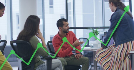 Image of graph over diverse coworkers sharing ideas in office