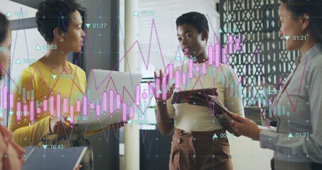 Obraz premium Image of multiple graphs with changing numbers, diverse female coworkers sharing ideas in office