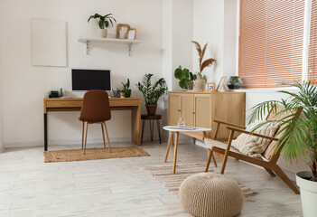Interior of office with workplace, drawers and green houseplants