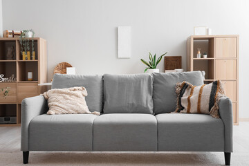 Grey sofa with stylish cushions in modern living room interior