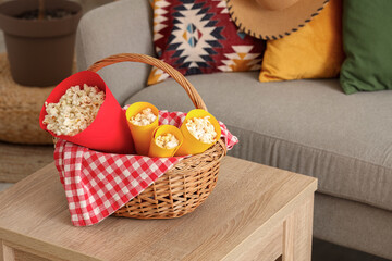 Fototapeta na wymiar Wicket basket with popcorn on coffee table in living room. Festa Junina celebration