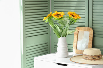 Vase with sunflowers on chest of drawers at home. Festa Junina celebration
