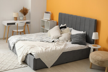 Modern bedroom with bed, bedside table and workplace