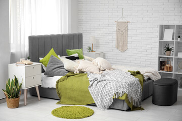 Modern bedroom with bed, bedside tables, pouf and shelving unit