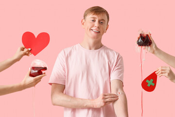 Male blood donor and hands with packs for transfusion on pink background