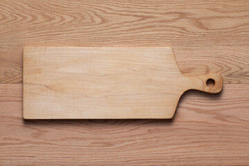 Handmade maple wood cutting boards sit on an oak tabletop. Handmade wooden cutting board.