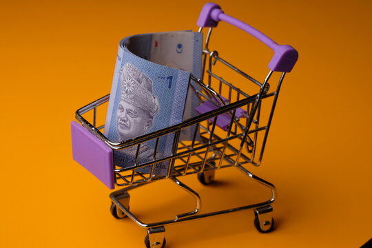 Shopping cart full of money (Malaysian Ringgit). Multi currency basket concept. RM. Satu ringgit Malaysia. One Ringgit Malaysia. Economy concept. 

