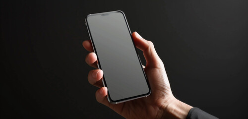 A hand holding a modern mobile phone with a blank screen, set against a black background for maximum contrast, perfect for showcasing digital designs or interactive prototypes, the image rendered. - Powered by Adobe