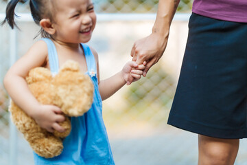 young mom shares a tender moment with her playful, happy Asian two-year-old female toddler, as they...