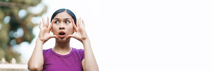 A young Asian woman appears panicked outside her home. She exhibits signs of anxiety, fear, and...