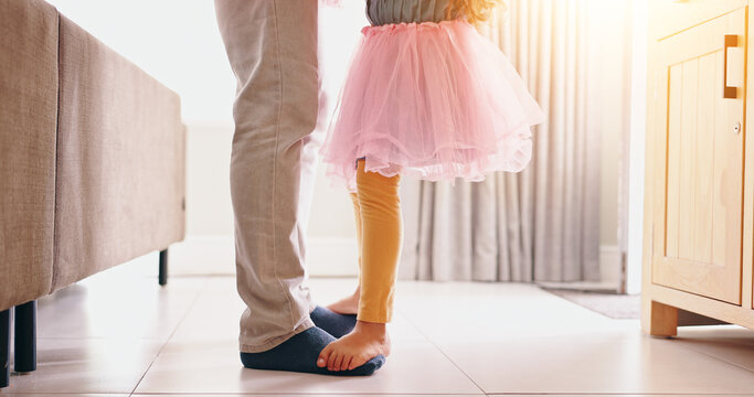 Father, child and dancing on feet in home with music, radio or bonding with love in living room. Dancer, energy or girl in ballerina dress in lounge with teaching, steps or movement in house for care