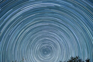 Star trail of stars moving in the night sky around the North Star. Landscape with movement of stars...