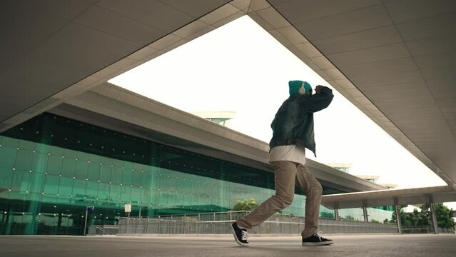 Panorama shot of happy hipster dance together while listen music from headphone at mall. Professional break dancer enjoy perform b boy footstep. Outdoor sport 2024. Modern street dancing. Sprightly.