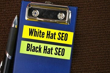 pens, signs and colored paper with the words White Hat SEO and black Hat SEO. SEO techniques are...
