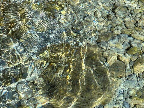 Stones pebbles in the clear sea water.