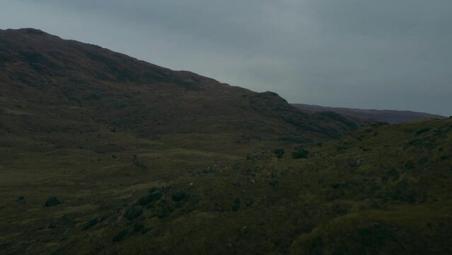 Low dolly in flight in the Highlands of Isle of Mull, Scotland reveals a lush green mountainous landscape
