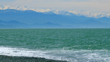 Blue Sea Water With Far Away Mountain Coastline On The Horizon. Real time.