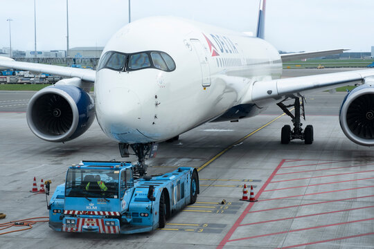Delta airlines Boeing being pushed back by a pushback tug tractor in Amsterdam Schiphol Airport, the Netherlands, February 21 2024
