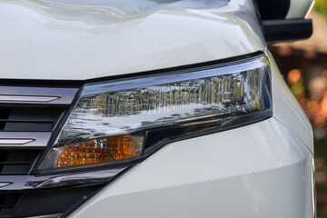 Headlights and hood of sport white car with silver stars