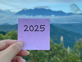 2025 on paper. New year resolution concept with nature background. Stock photo.
