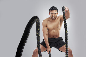 Battle ropes, man and portrait in studio for exercise, fitness and core workout on gray background....