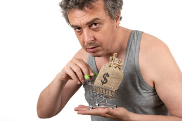 A shaggy gray-haired unshaven man in a sleeveless T-shirt holds a miniature shopping cart from a...