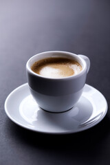 Cup of coffee on dark paper background. Soft focus. Close up. Copy space.
