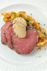 steak with side dish and sauce on a plate