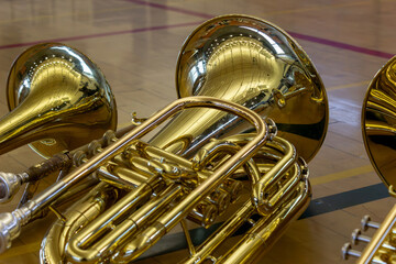 Baritone Lies Next to Other Brass Instruments on Basketball Court.