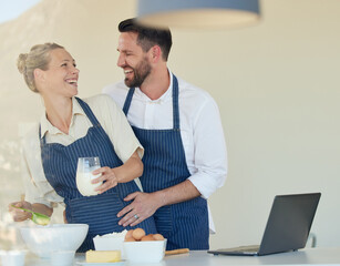 Couple, bake and love with apron in kitchen, smile and bonding together for food, fun and eggs in house. Happy, man and woman with embrace, entrepreneur and chef in home with flour for dessert