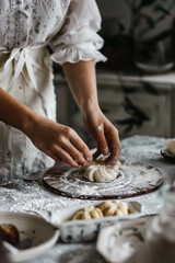 A woman in white preparing dough for a pastry. - obrazy, fototapety, plakaty