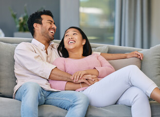 Asian couple, happiness and relax on sofa in living room for love, support or conversation....