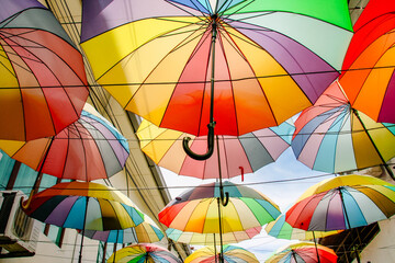 colorful umbrellas that hang up as an art installation in a alley