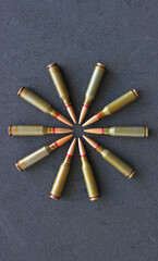 Combat bullets laid out in a circle shape on a black surface vertical stock photo